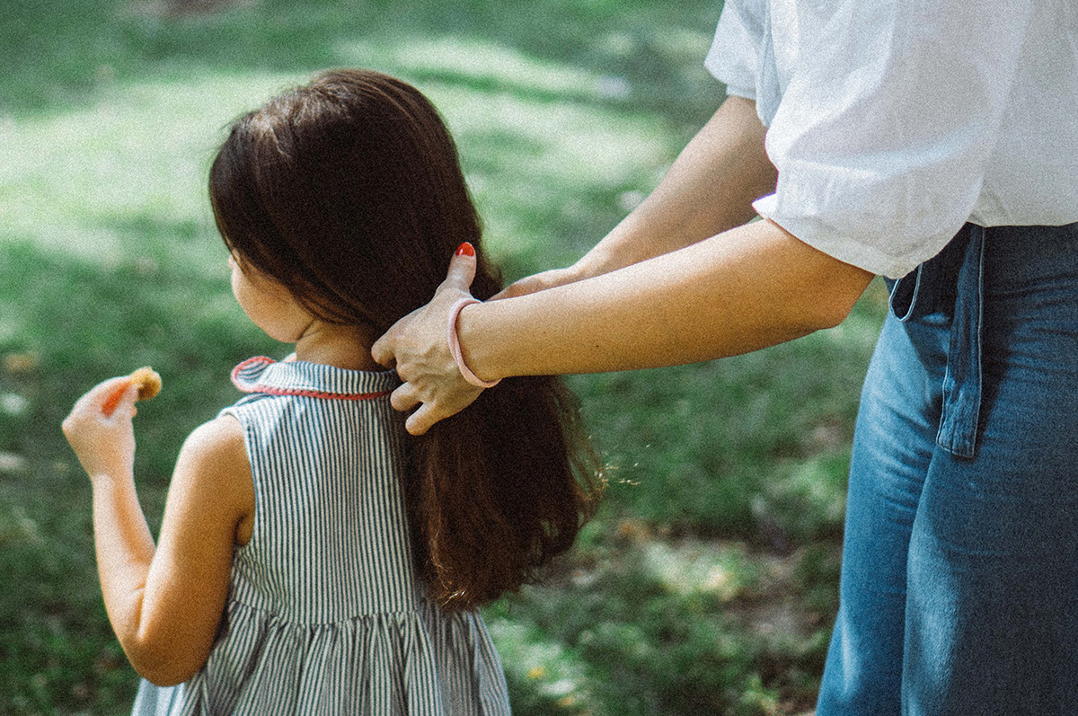 Close cropped image of a mother putting her daughters hair into a ponytail